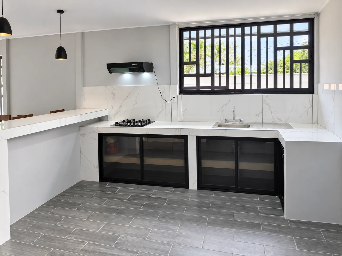 Cocina con ventana calada en hierro y cubierta en cuarzo